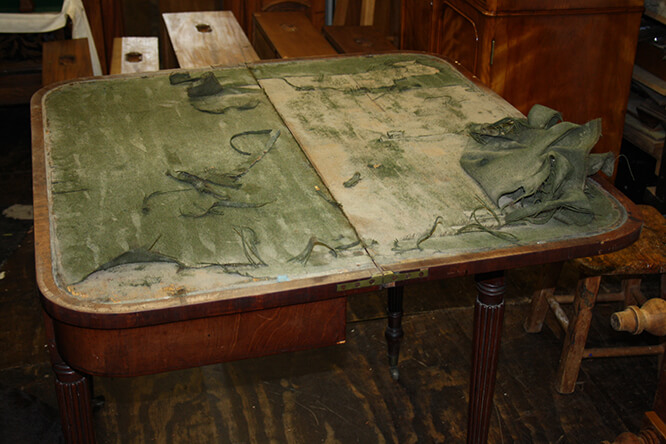 TABLE WITH DAMAGED BAIZE